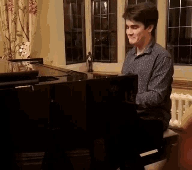 a man is playing a piano in a living room .