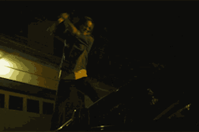 a person standing on top of a car in front of a building with the number 1441 on it