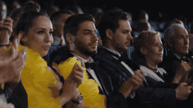 a group of people applauding in a theater