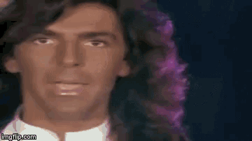 a close up of a man 's face with purple hair .