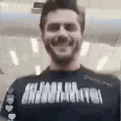 a man with a beard and sunglasses is wearing a black shirt with the word miami on it .