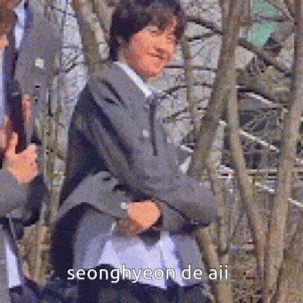 a man in a suit is standing with his arms crossed and says seonghyeon de aii on the bottom
