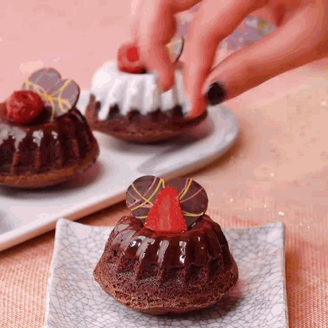 a person is decorating a chocolate cake with a strawberry
