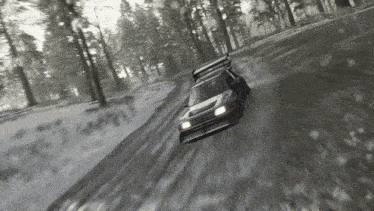 a car driving down a snowy road with trees in the background