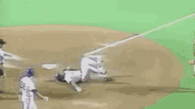 a baseball catcher is kneeling down on the field while a baseball player runs towards him .