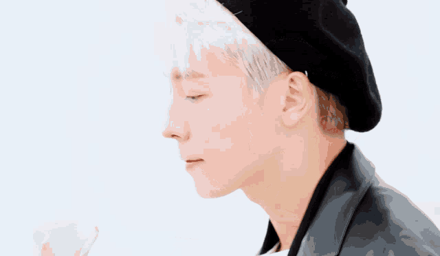 a man with white hair and a black hat
