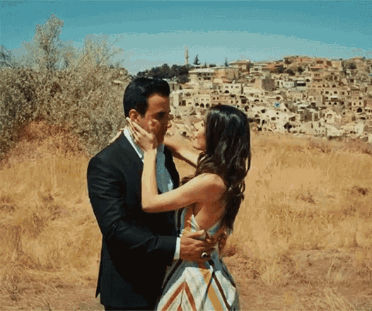 a man and woman are kissing in front of a city