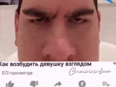a close up of a man 's face with a russian text behind him