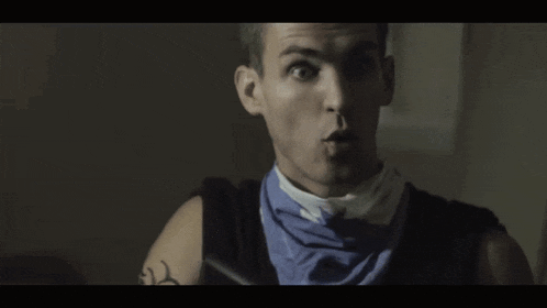 a man wearing a blue and white scarf around his neck is making a funny face