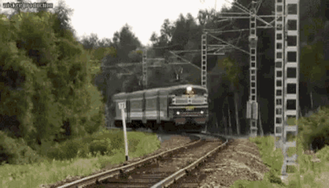 a train is going down the tracks with a sign that says ' no '