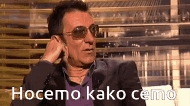 a man wearing sunglasses talks on a cell phone