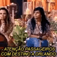 a group of women are sitting next to each other in a room with a sign that says atenção passageiros