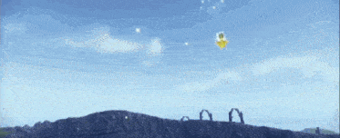 a yellow object is flying in the sky over a mountain .