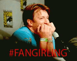 a man sitting in front of a microphone with the hashtag #fangirling on the bottom