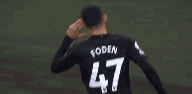 a soccer player wearing a black jersey with the number 29 on it is standing on a field .