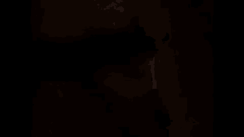 a close up of a person 's face in a dark room with a blurred background .