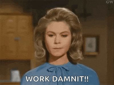 a woman in a blue shirt is standing in a kitchen and saying `` work damnit '' .
