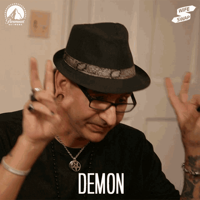 a man wearing glasses and a hat with the word demon written on it