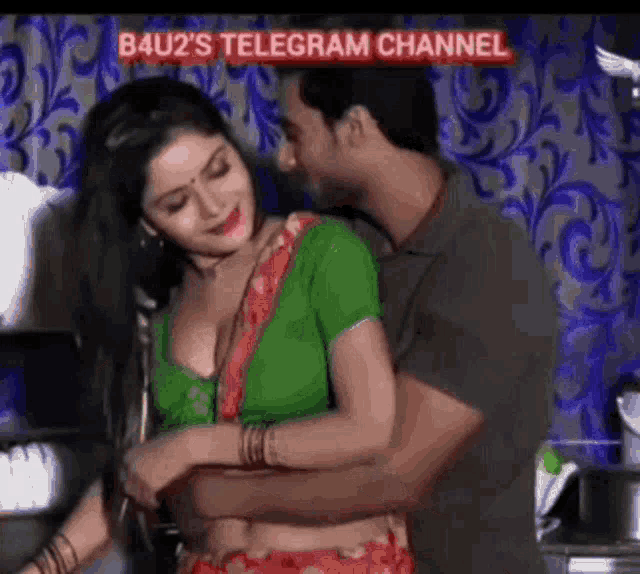 a man is hugging a woman in a green blouse in a room .