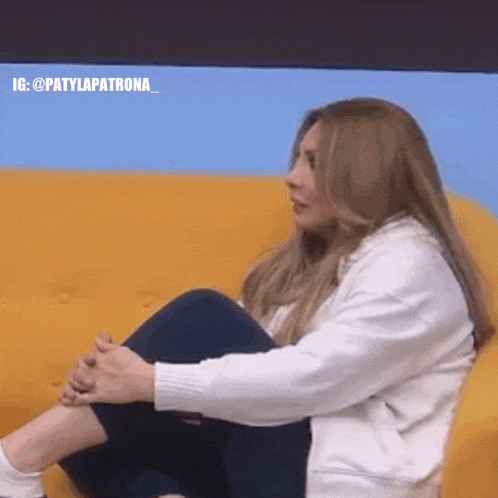 a woman is sitting on a couch with her legs crossed .