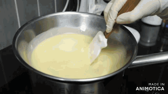 a person is stirring a pot of liquid with a spatula and the words made in animotica on the bottom