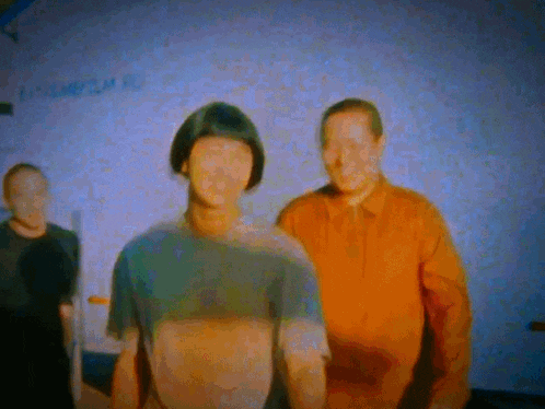 a group of men are standing in front of a wall that says " tomorrow " on it