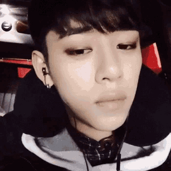 a close up of a young man wearing headphones and a black jacket .