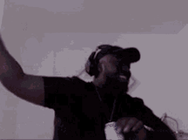 a man wearing headphones and a hat is making a funny face