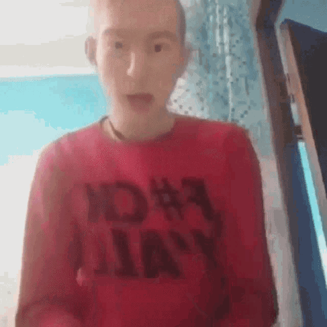 a young man wearing a red shirt that says navy