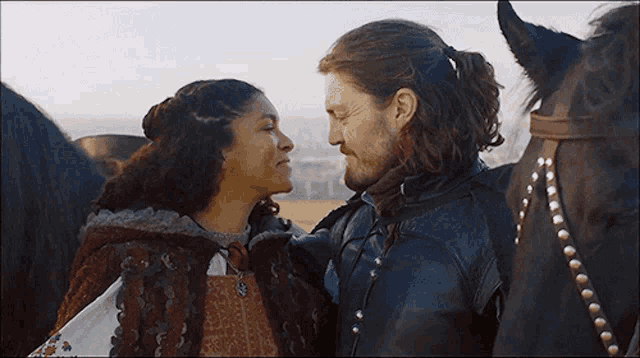 a man and a woman are standing next to each other and looking at each other .