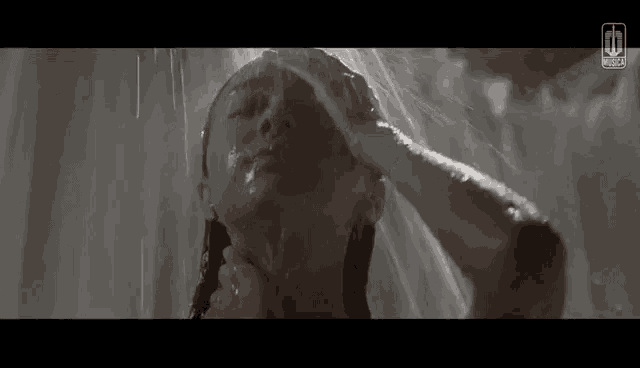 a woman is taking a shower under a shower head .
