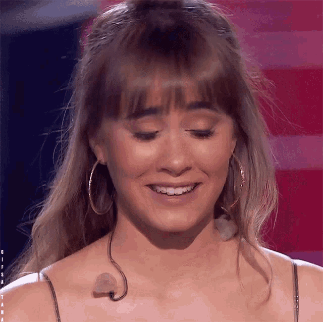 a close up of a woman 's face with a microphone sticking out of her neck