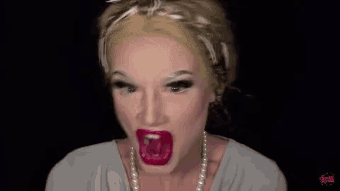 a close up of a woman making a funny face with her mouth open .