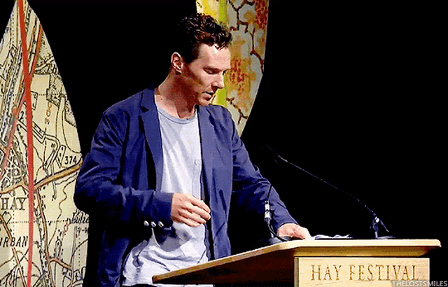 a man stands at a podium with hay festival written on it