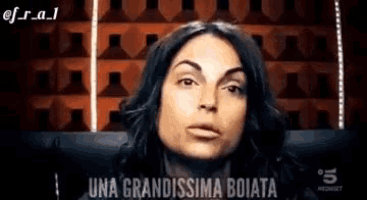 a close up of a woman 's face with the words `` una grandissima boiata '' written on it .