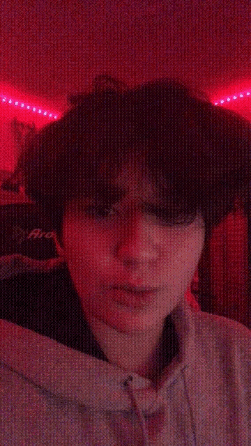 a close up of a person 's face in front of a red background