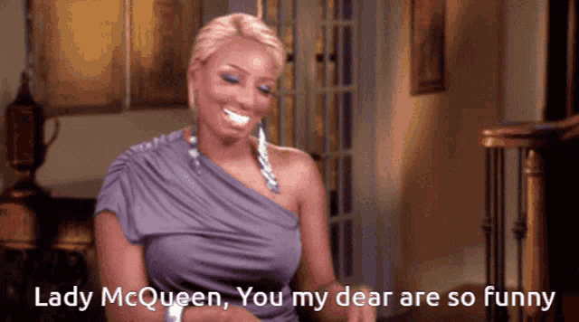 a woman in a purple dress is smiling and saying lady mcqueen you my dear are so funny