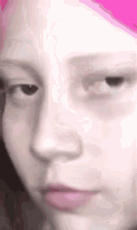 a close up of a girl 's face with pink hair and a pink lip .