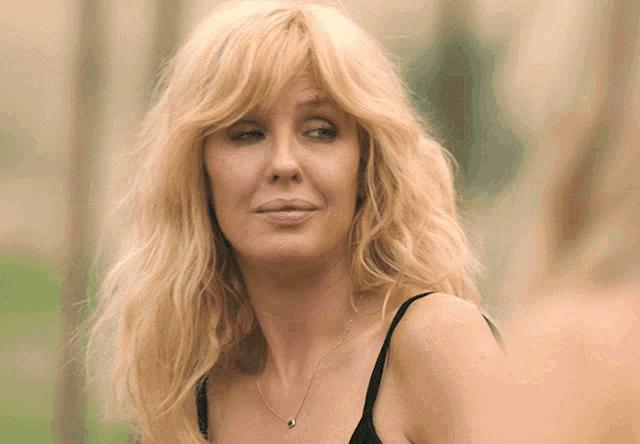 a woman with blonde hair and a black tank top