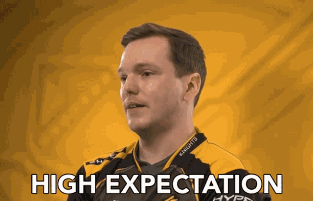 a man in a black and yellow shirt with the words high expectation written on the bottom
