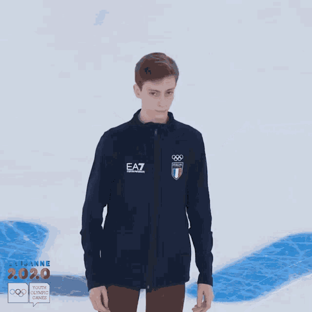 a young man wearing a blue ea7 jacket