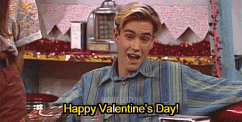 a young man is sitting in front of a red car and saying `` happy valentine 's day ! ''