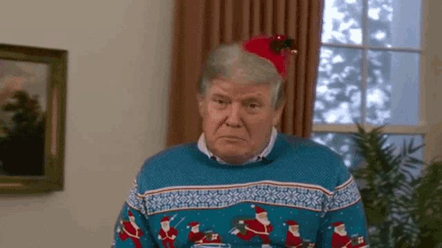 a man wearing a christmas sweater and a santa hat .