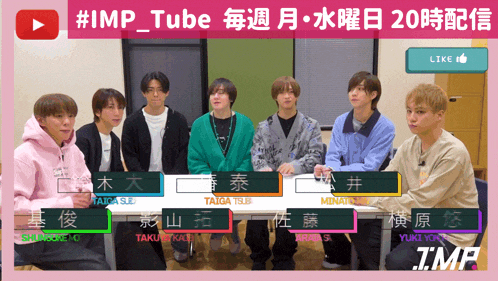 a group of young men are sitting around a table with their names on them