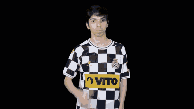 a man wearing a black and white checkered shirt with the word vito on the front