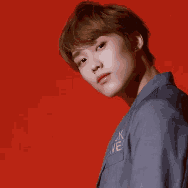 a close up of a young man 's face on a red background