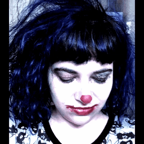 a woman with blue hair and a red nose