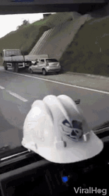 a white hard hat is sitting on a car window