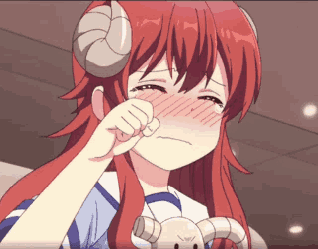 a girl with red hair and horns is crying with her hand on her face