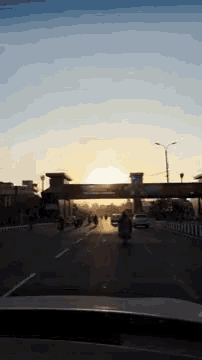 a car is driving down a highway at sunset .